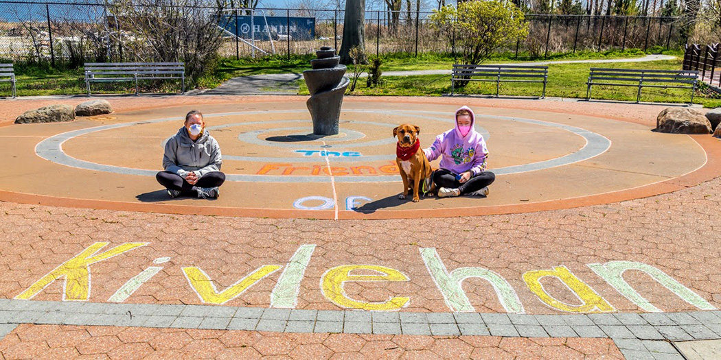 Community members pose with a dog in a circle that reads Friends of Kivlehan