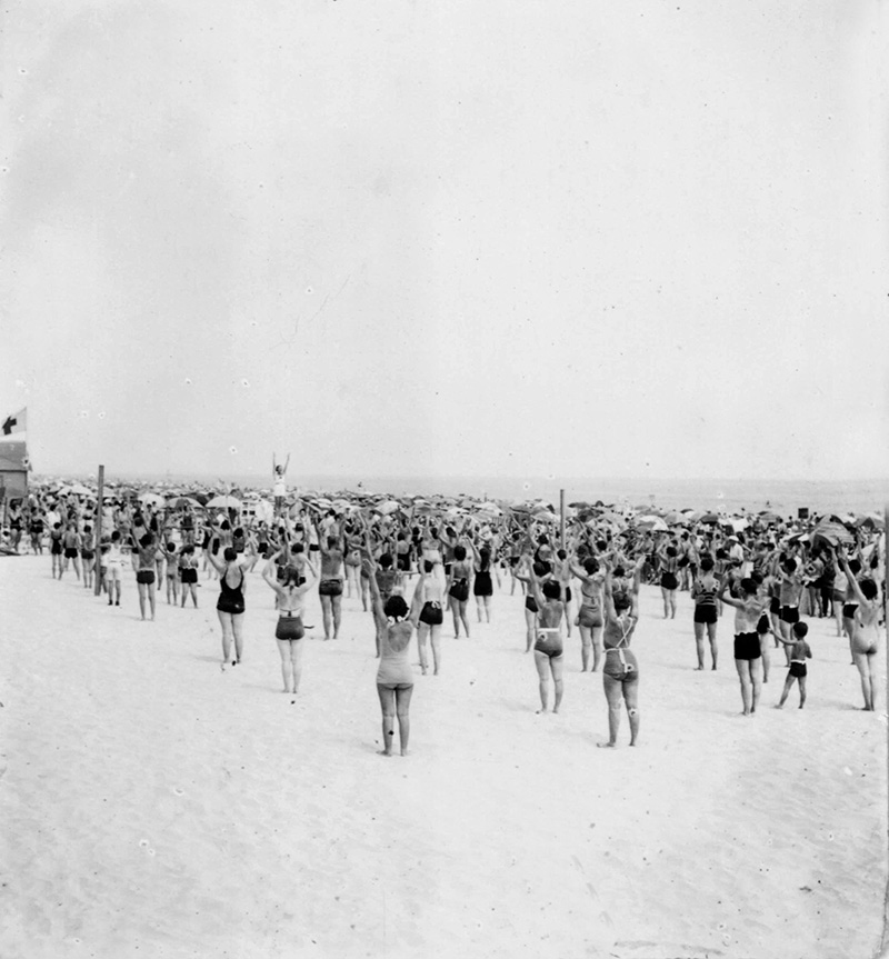 black and white archival image of folks working out together on the beach