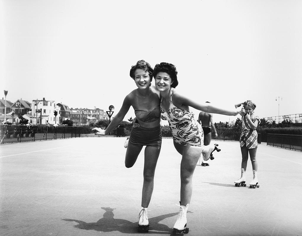 black and white archival image of two roller skaters embracing each other