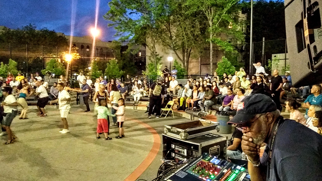 Community members dance along as the DJ queues up the next song