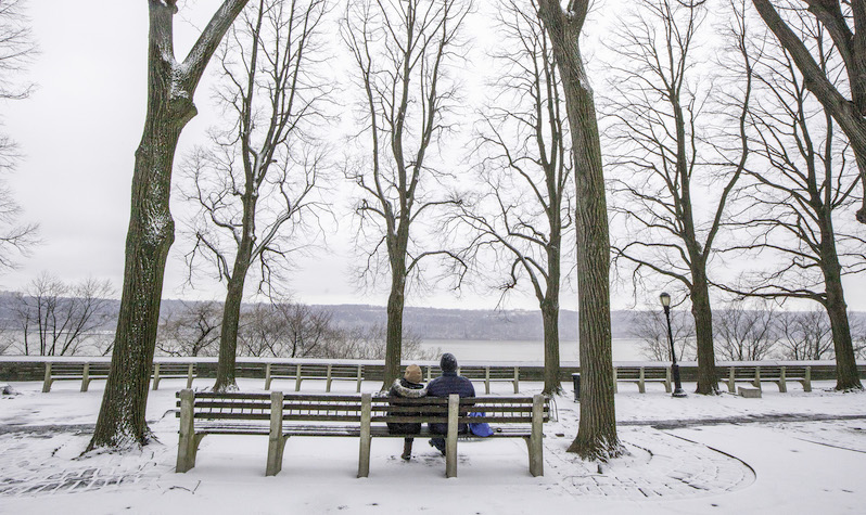 A couple sits and enjoys the view of the palisades