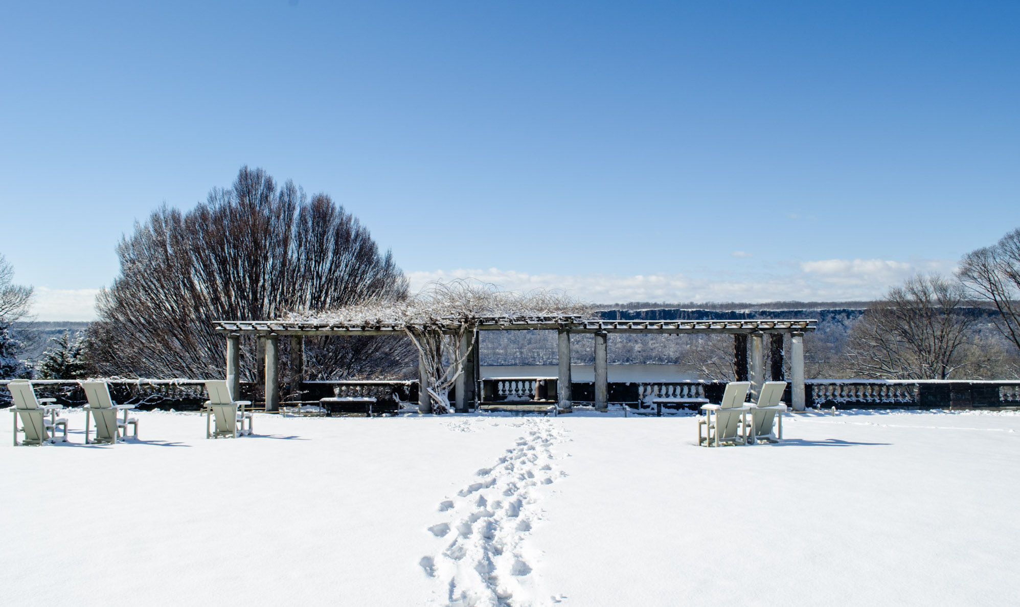 Footprints in the snow leads to a lookout spot with adirondack chairs