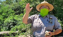 a park ranger waves while in the park