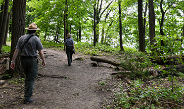 rangers hike through a trail in the park