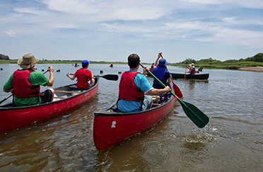 folks canoe in the creek surrounded by a salt marsh