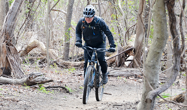 A person riding a mountain bike through a trail.