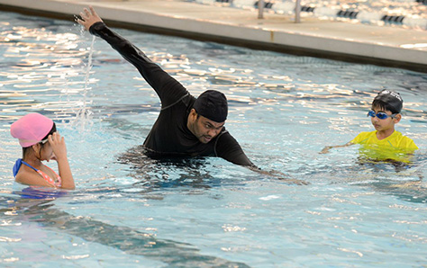 instructor teaching kids how to swim