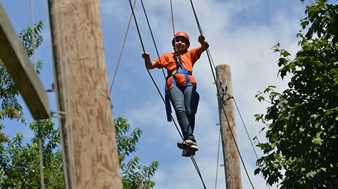 a kid makes their way across a catwalk above ground