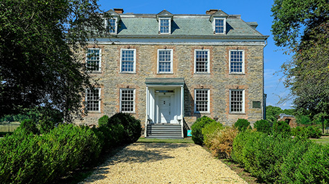 View of a pathway that leads to a historic stone house