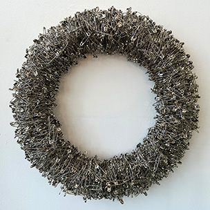 A circular wreath made of safety pins