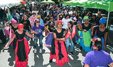 people dance together at event during GreenThumb harvest fair