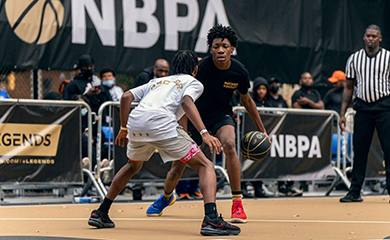 two teens play basketball