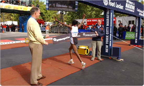 Mayor Bloomberg holds the finish line banner for the first woman to complete the 2002 New York City Marathon. Photo by Spencer T. Tucker.