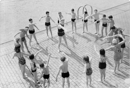 Children gathers around a Learn to Swim program instructor and practice their strokes, 1940. Courtesy of Parks Photo Archive, Neg. 53237-1.