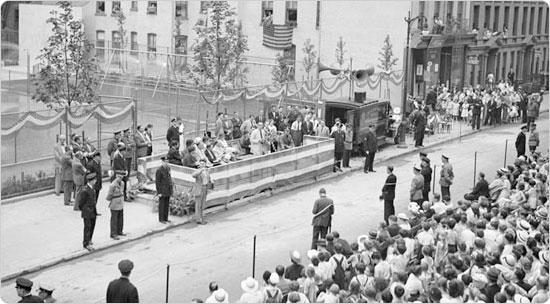 Neighbors peer from windows and a large crowd gathers in front of Gertrude B. Kelly Playground for its opening ceremonies, August 8, 1934.