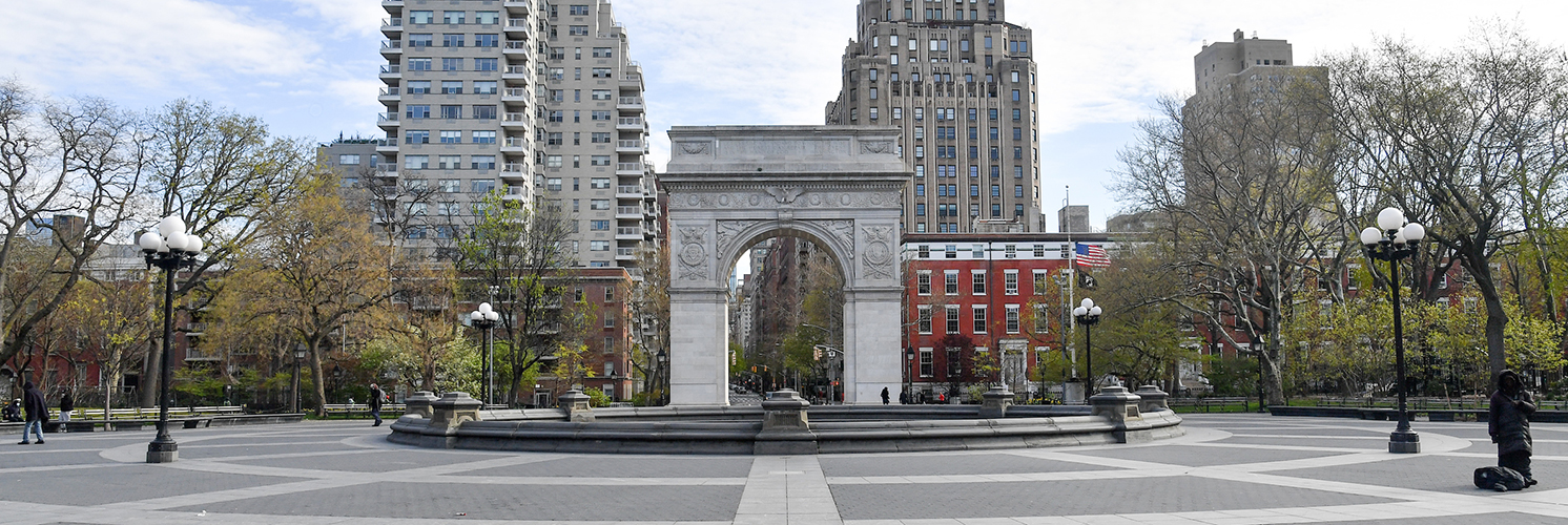 A recognizable photo of the grand arch in Washington Square Park on a sunny day in early spring.