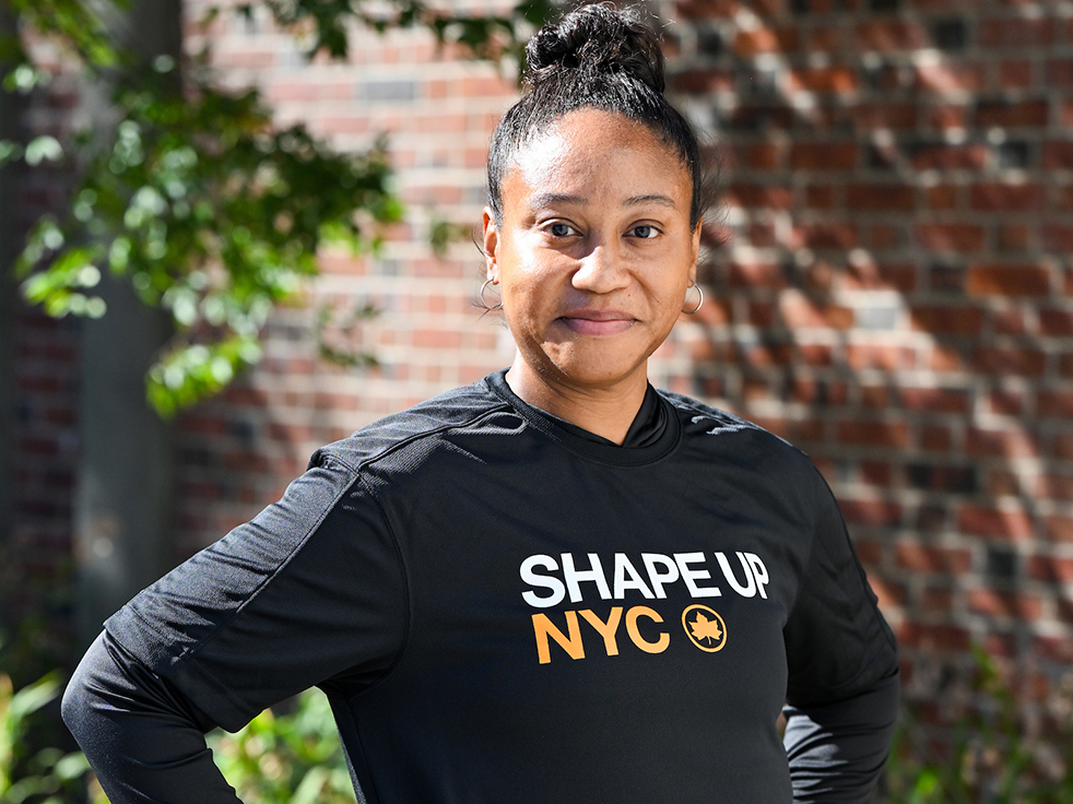 an instructor wears a black hoodie with Shape Up NYC logo and poses for a photo