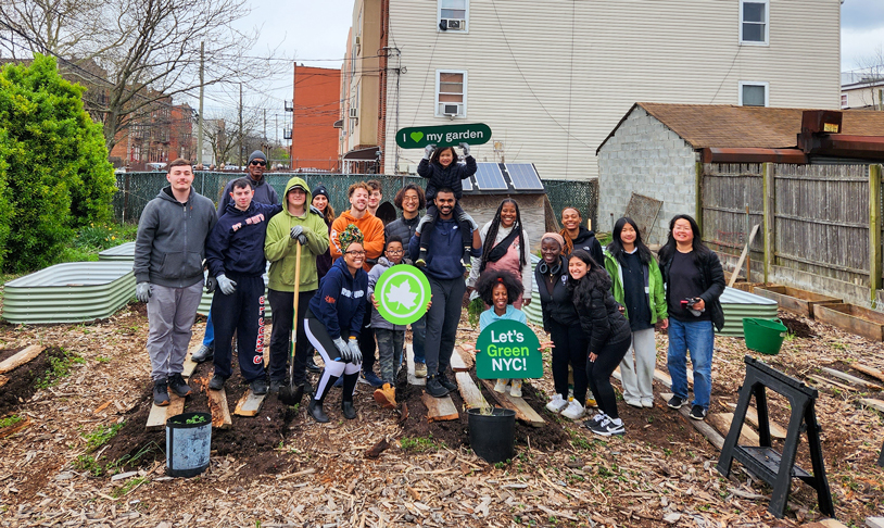 a group of attendees at earth month post for picture with signs