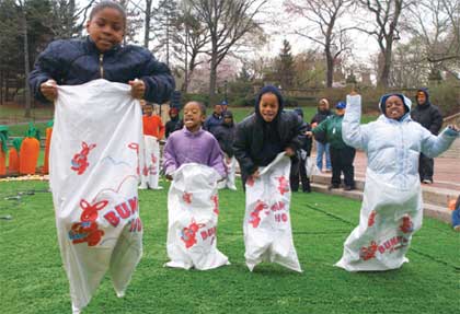 Kids participate in a sack race at Central Park's Easter Eggstravaganza event.