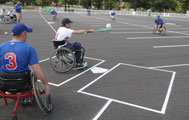 Athletes in wheelchairs play softball