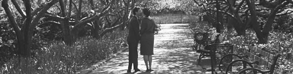 A couple kiss under the trees in the Conservatory Garden in Central Park