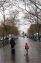 Mother and child walking in Dag Hammerskjold Plaza on rainy afternoon.